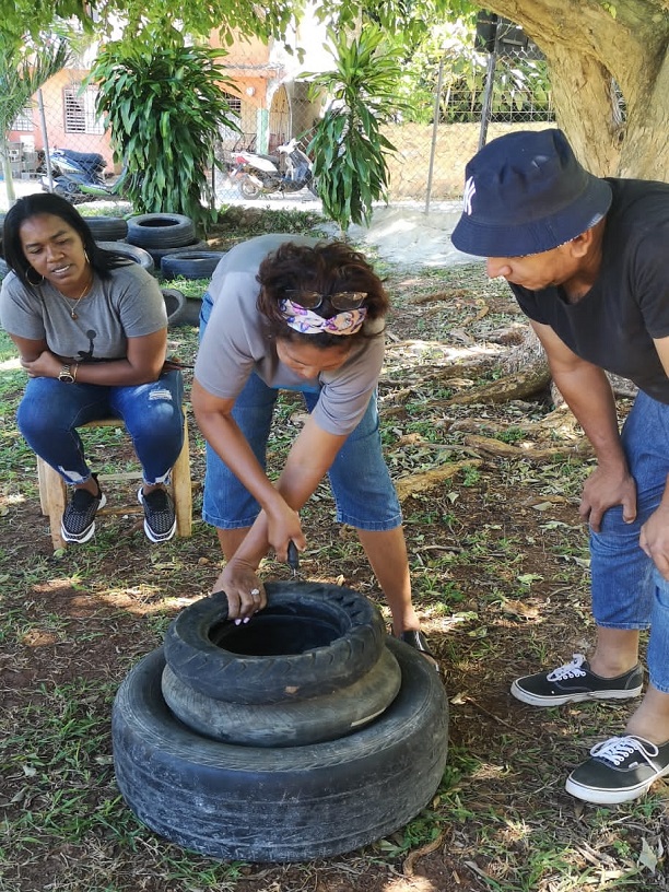 Frau die mit Reifen bastelt während ihr zwei Personen dabei zuschauen