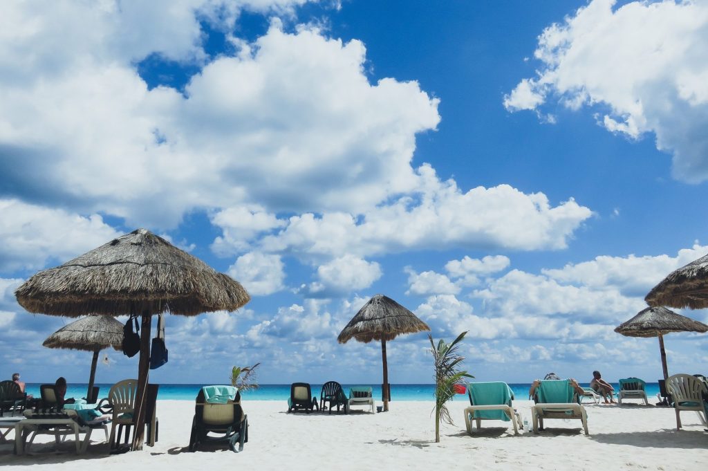 Bewölkter Strand mit Sonnenschirmen