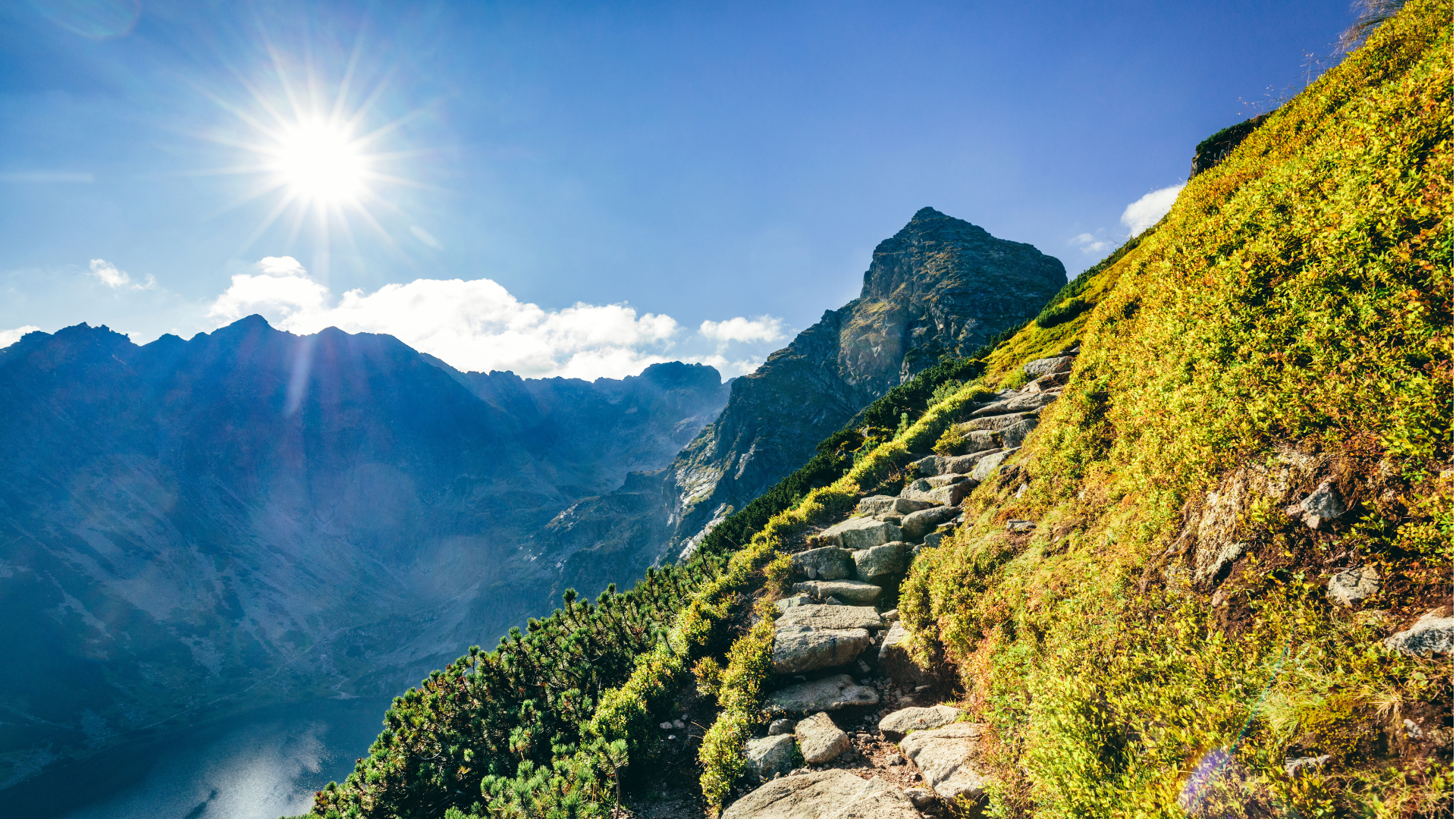 Ein schmaler Bergaufstieg mit einem Fluss im Hintergrund bei schönem Wetter