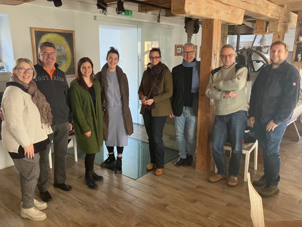 A group photo taken at a tourist establishment in Burgenland, featuring men and women looking at the camera.