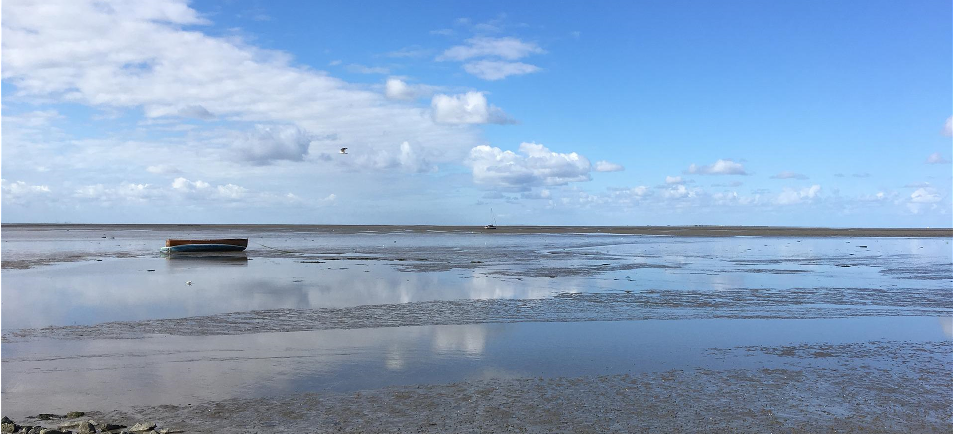 Blick über das Wattenmeer mit einem kleinen Boot